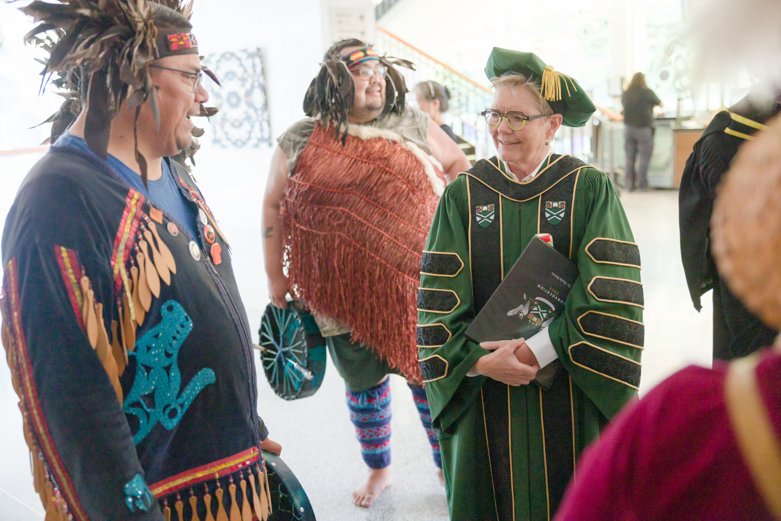 Dr. Paula Burns in regalia speaking with the Musqueam community who provided the welcome for convocation