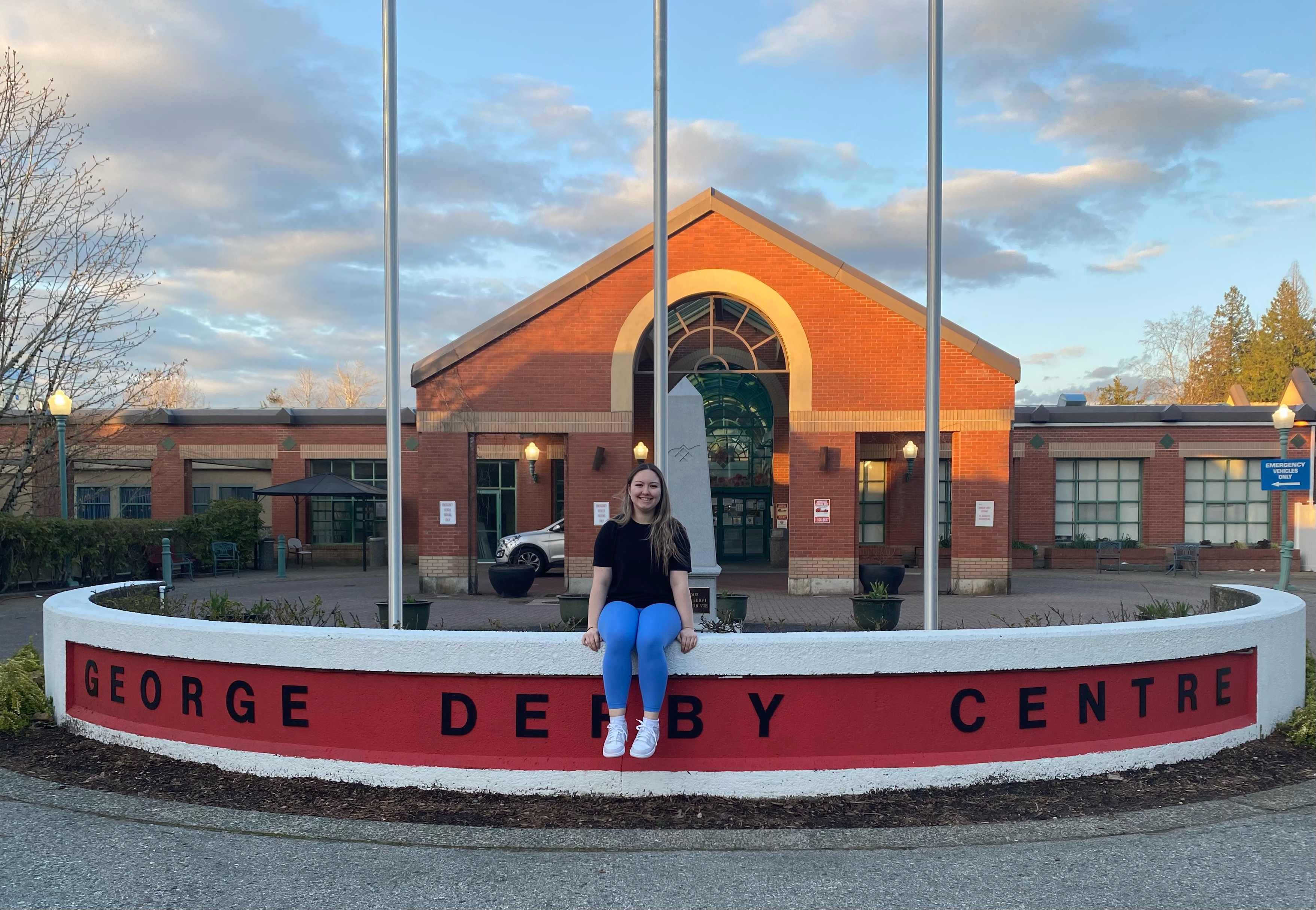 woman sitting on a bench outside of a recreation centre