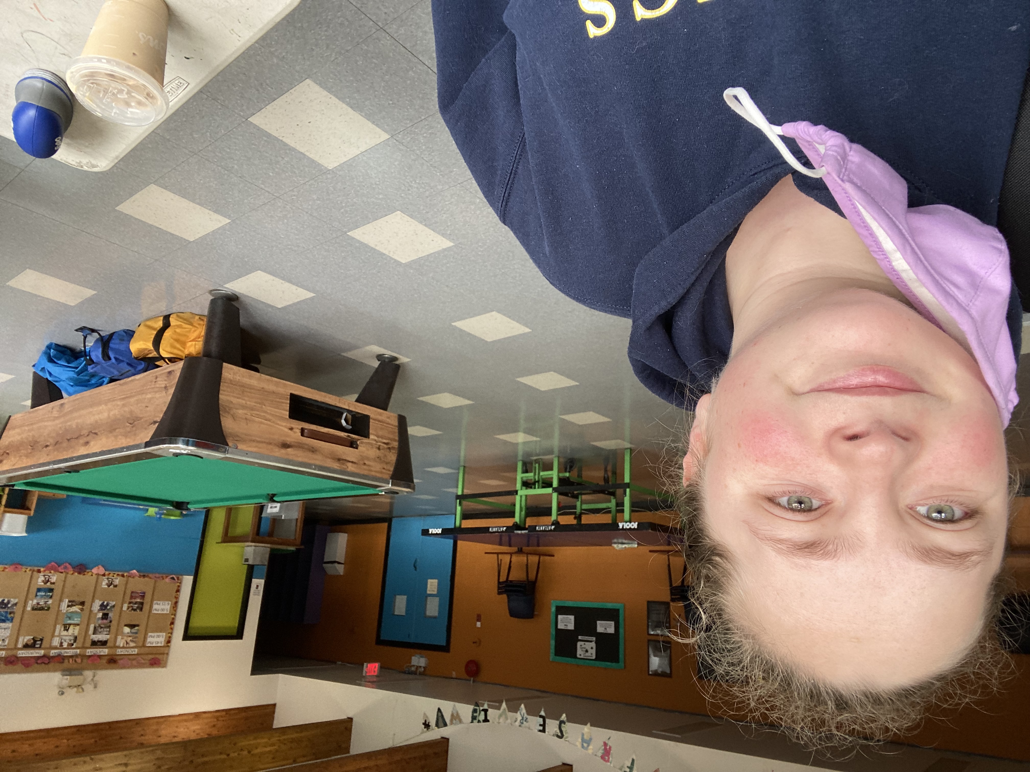 Woman smiling in games room with pool table and ping pong table in the background