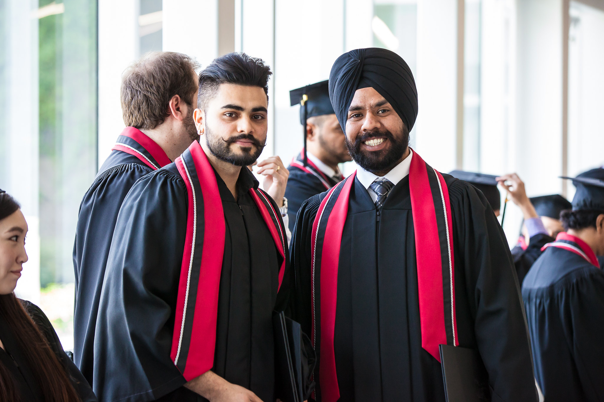 two graduates pose for a photo